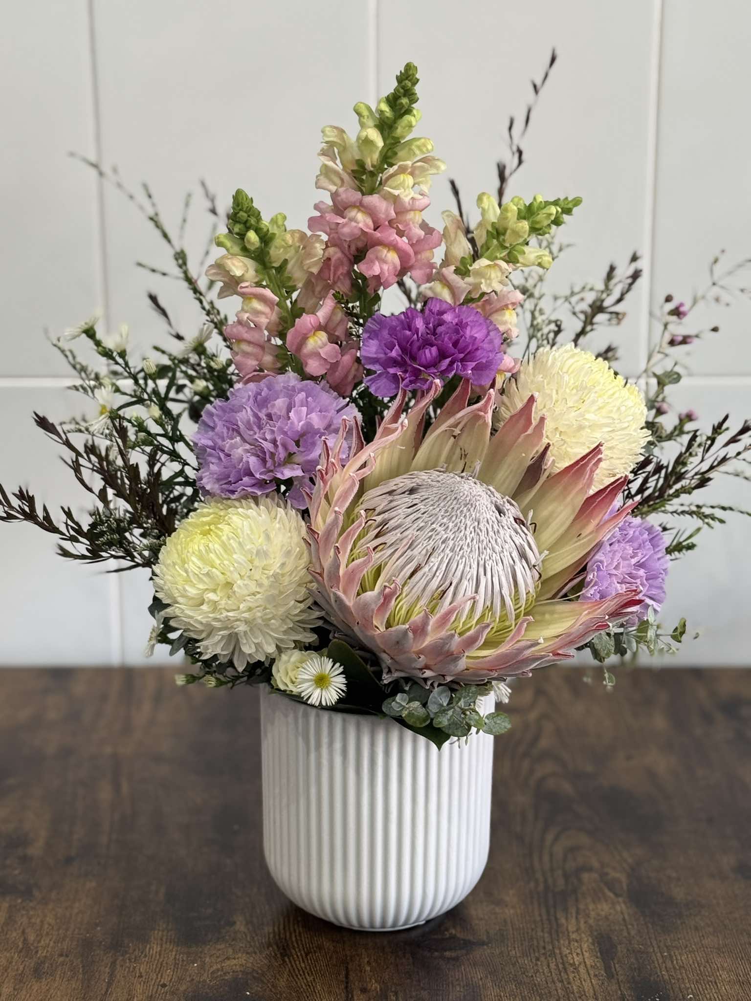 Fresh protea and purple flower arrangement from Cattle Dog Florist in Muswellbrook